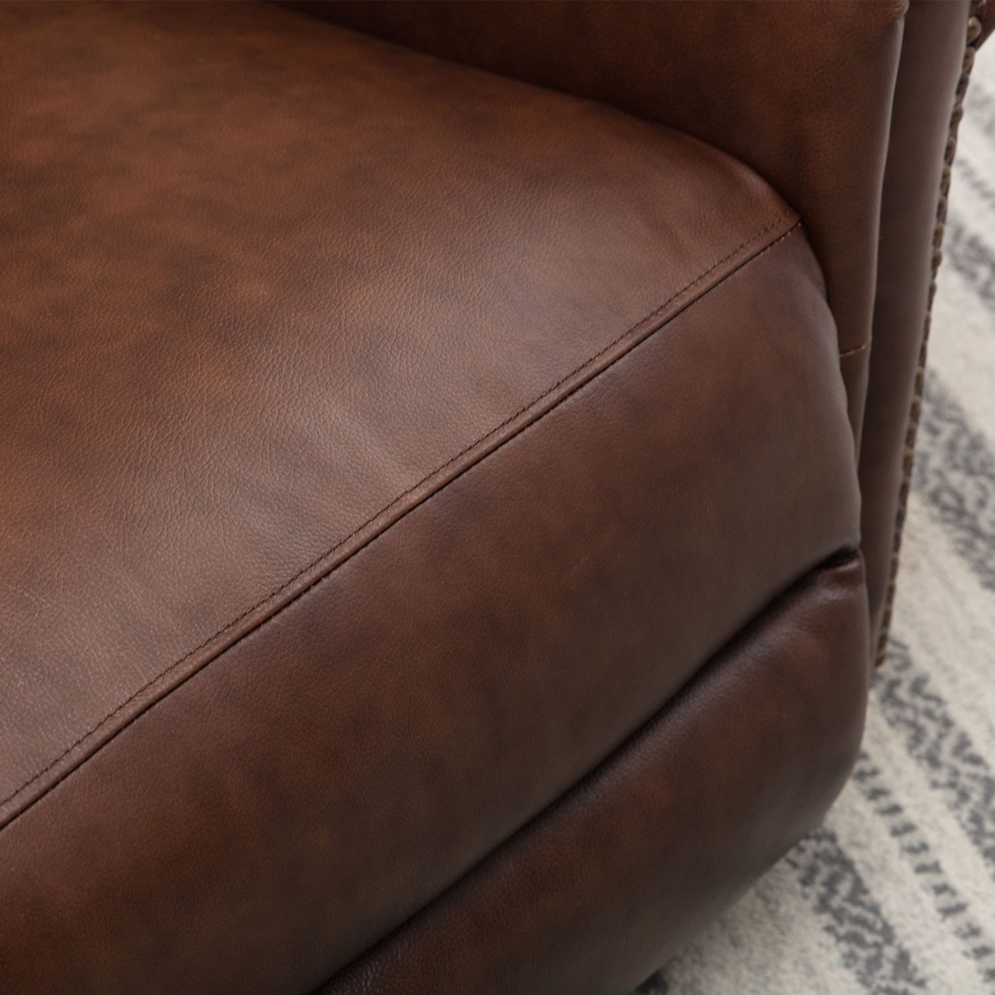Fauteuil inclinable en cuir véritable avec accoudoirs et dossier confortables.