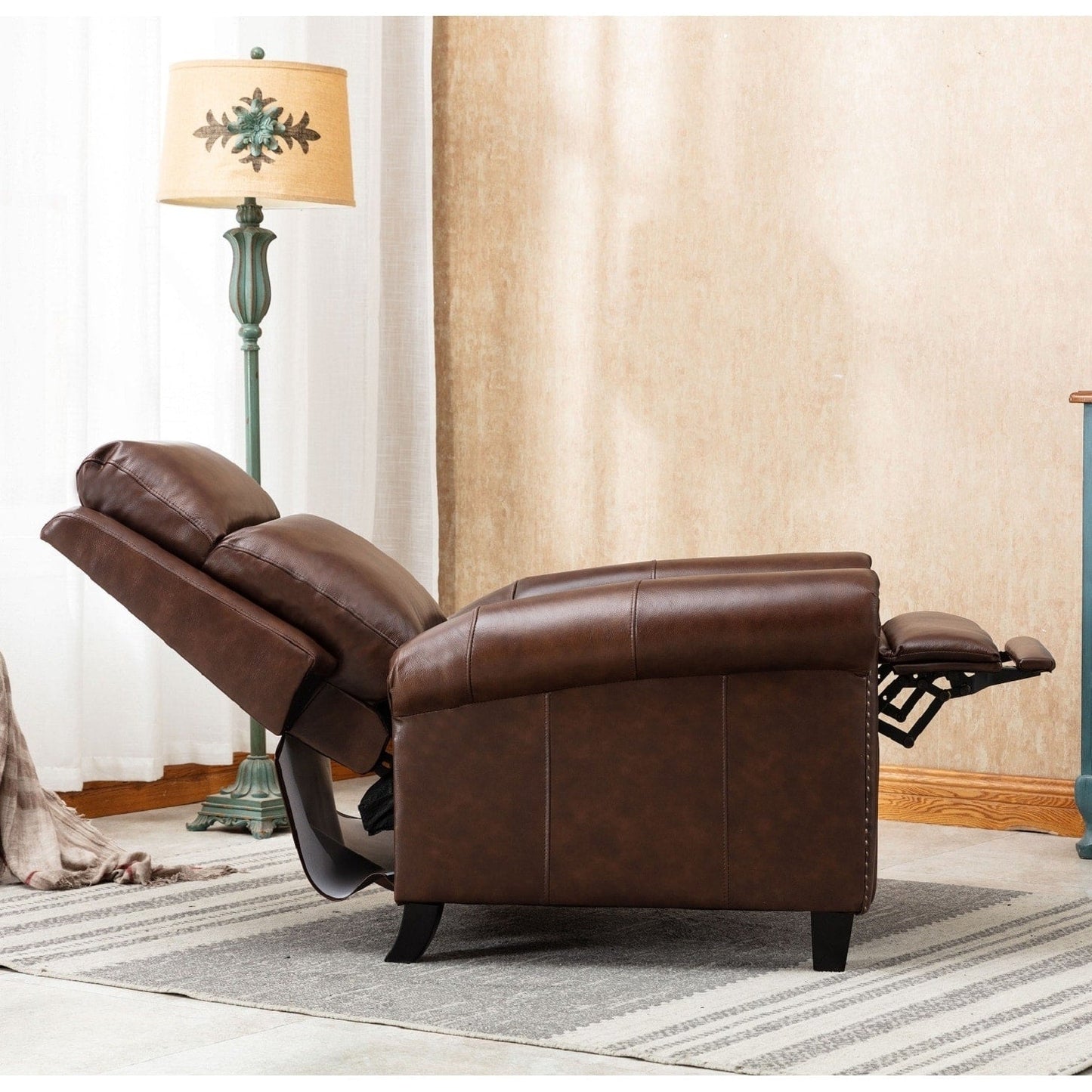 Fauteuil inclinable en cuir véritable avec accoudoirs et dossier confortables.